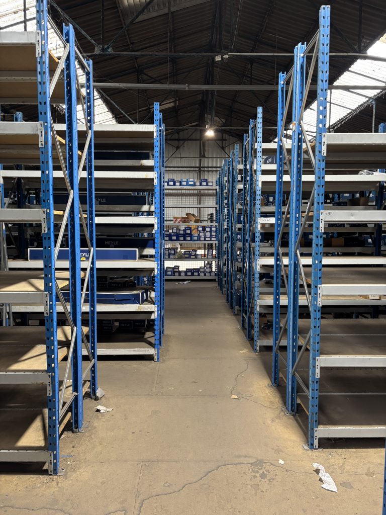 Photo prise dans l'allée principale et vue sur rayonnage bleu (plusieurs colonnes)